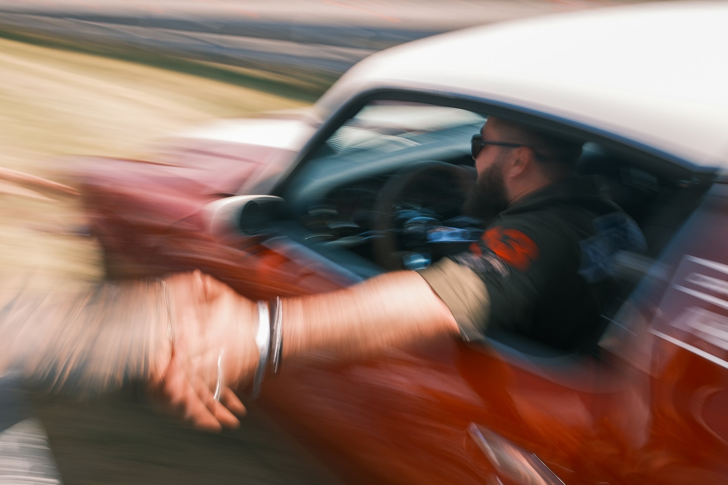 Fahrer eines roten Oldtimers in voller Fahrt beim Race 61 im Roadrunners Paradise
