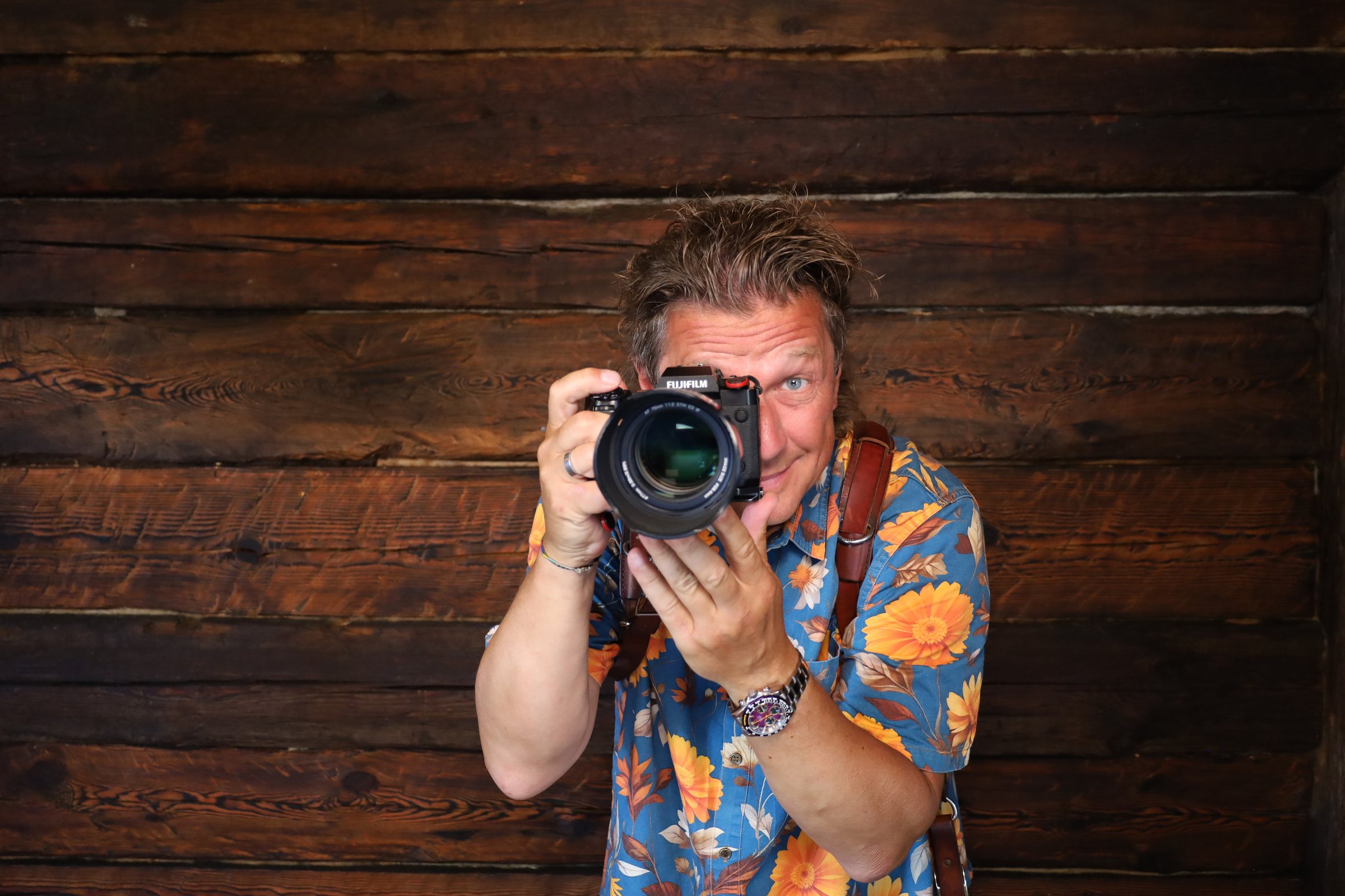 Torsten Kellermann fotografiert mit seiner Kamera vor einer alten Holzwand